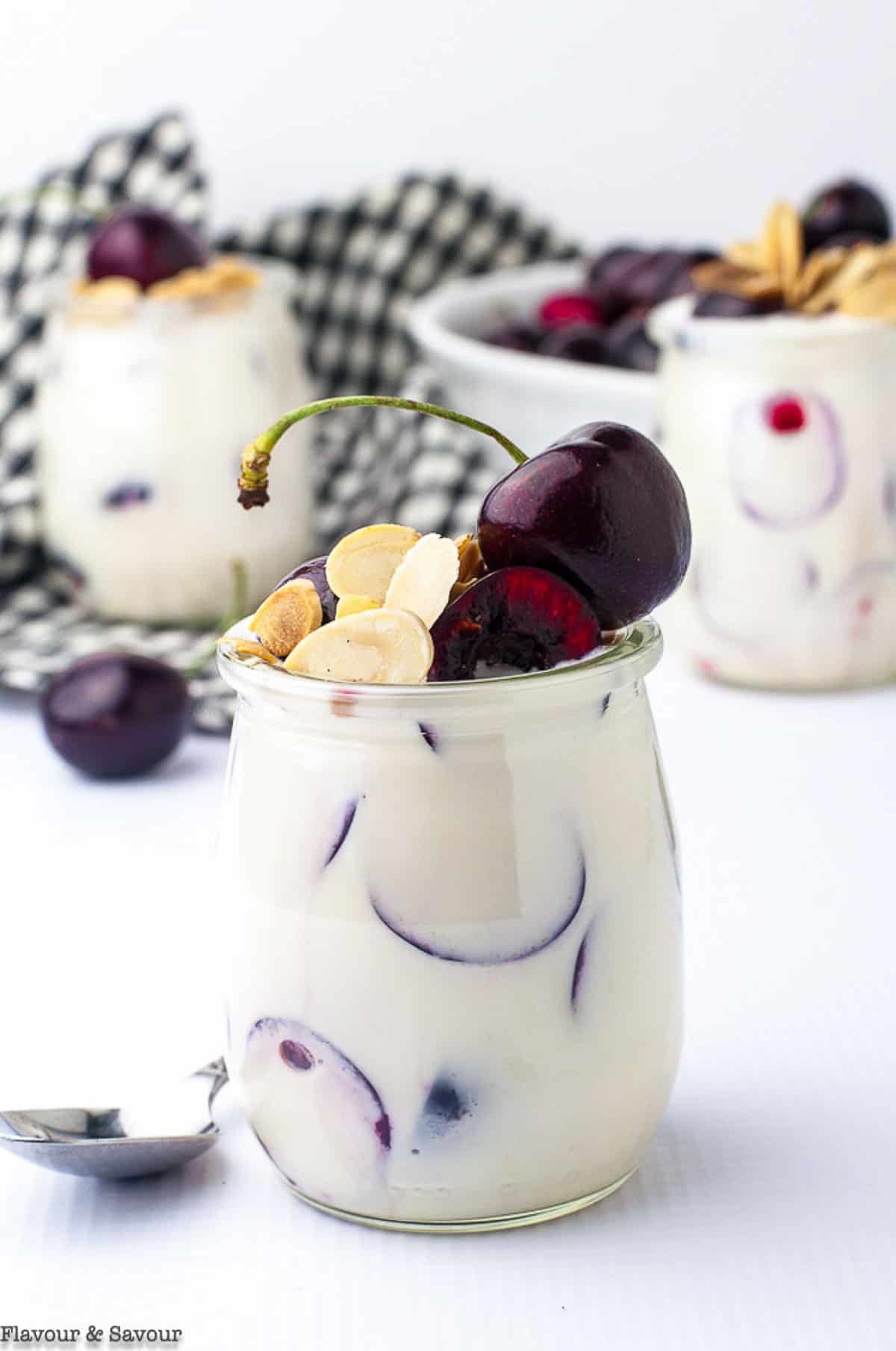 Close up view of a mini jar of cherry parfait with creamy lemon ricotta