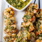 Grilled Chimichurri Shrimp Skewers with a small bowl of chimichurri sauce