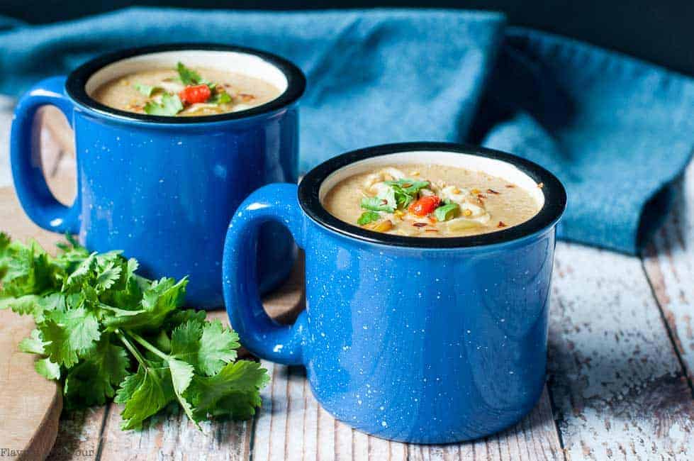 Two blue mugs of Slow Cooker Moroccan Harissa Cauliflower Soup with ciilantro
