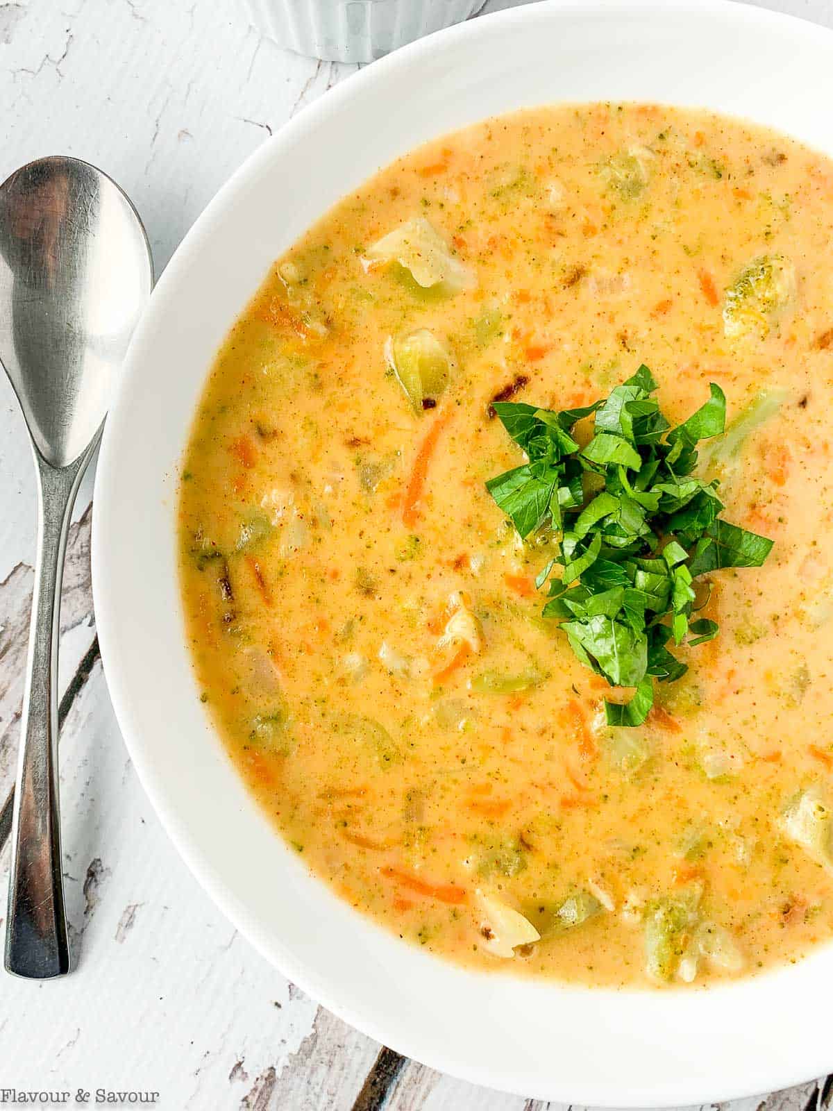 Close up view of Broccoli White Cheddar Soup garnished with parsley.