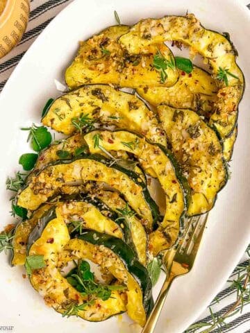 A platter filled with garlic parmesan crusted acorn squash slices.