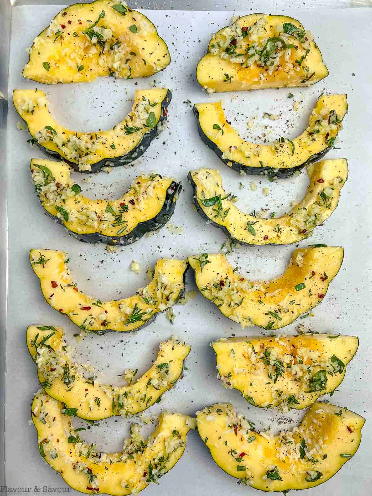 Acorn squash slices on a baking sheet.