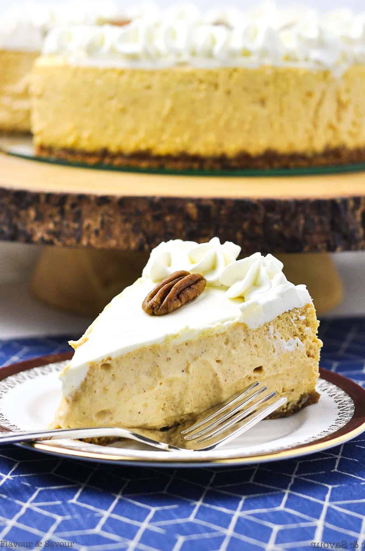 a wedge of gluten-free pumpkin cheesecake on a plate with the cake in the background