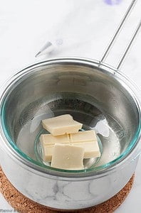 White chocolate melting in a bowl over a saucepan