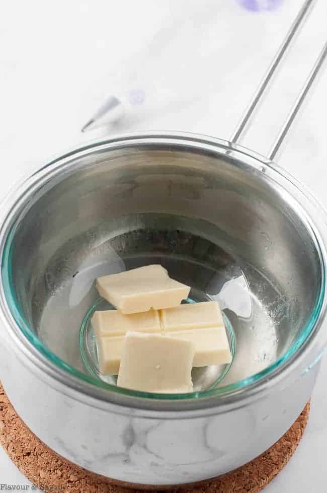 White chocolate melting in a bowl over a saucepan