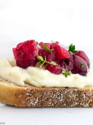 Close up view of a Cranberry Whipped Ricotta Crostini appetizer.