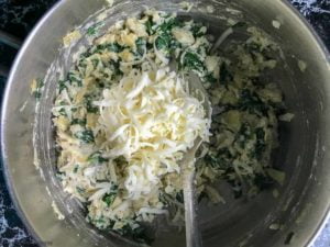 adding cheese for Mini Spinach Artichoke Tarts