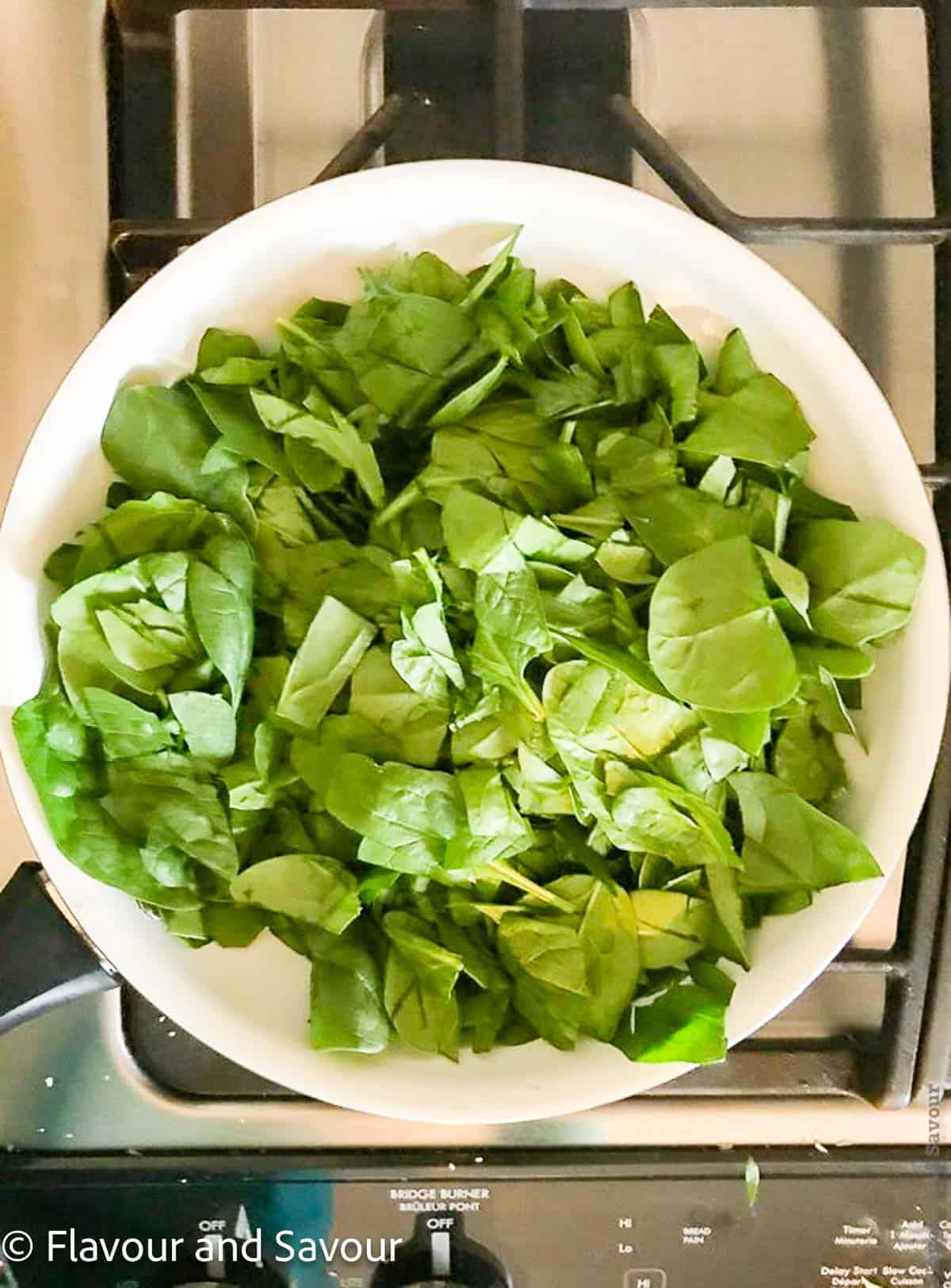 Fresh spinach leaves in a skillet.