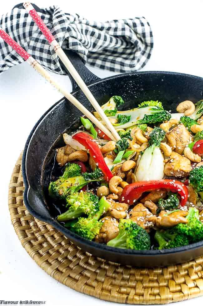 Stir Fry with chicken and broccoli in a cast iron pan with chop sticks