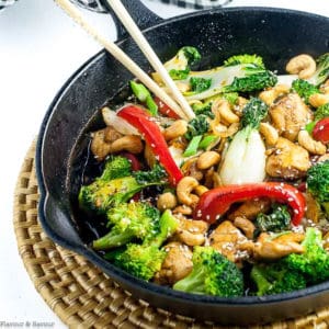 Chicken stir fry in cast iron pan with broccoli and red peppers