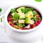a bowl of vegetarian chili topped with avocado