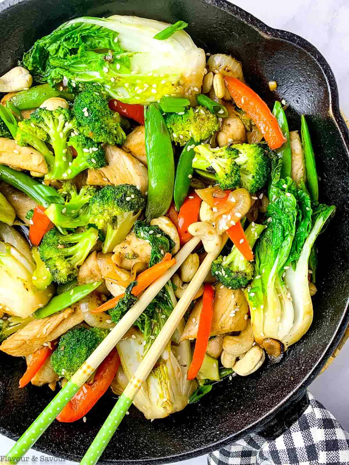 overhead view of a cast iron skillet with chicken stir fry.
