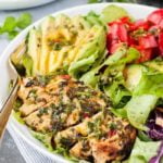 Close up view of Chimichurri Chicken Dinner Salad with mixed greens and sliced avocado