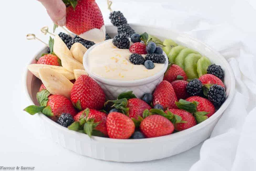 Dipping a strawberry into creamy Lemon Curd Fruit Dip