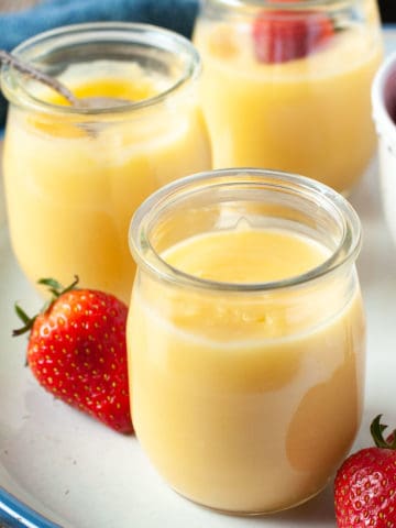 small jars of lemon curd with fresh strawberries