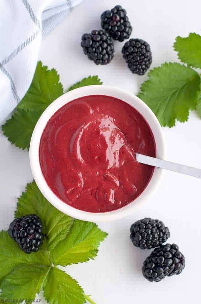 Blackberry Balsamic Dressing in a bowl surrounded by fresh blackberries