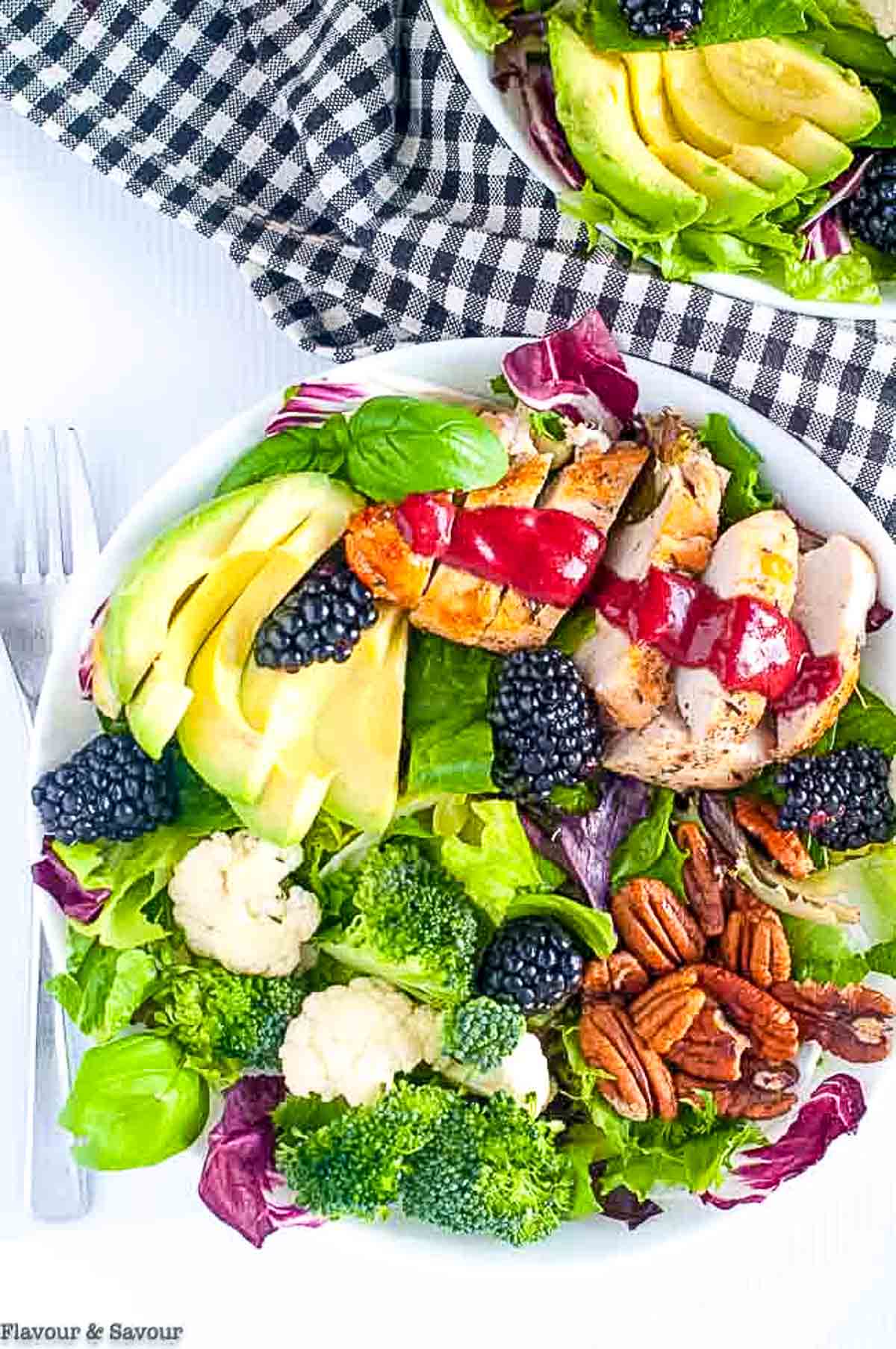 Overhead view of two bowls of blackberry balsamic grilled chicken dinner salad.