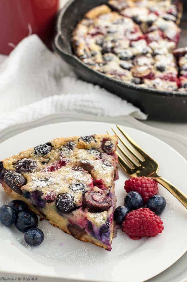 A slice of Cherry Berry Gluten-Free Clafoutis with fresh berries