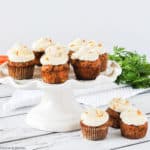 Mini gluten-free Carrot Cake Cupcakes on a white pedestal stand.