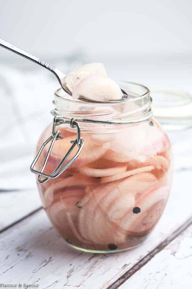 Spooning quick pickled shallots from a jar