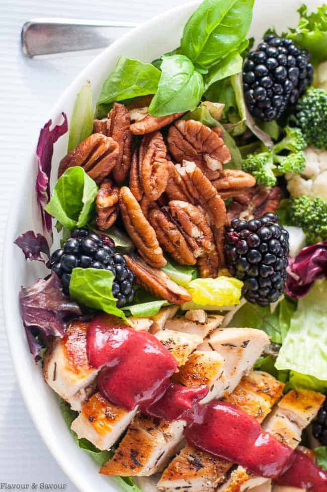 a bowl of chicken dinner salad with blackberry dressing