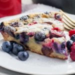 A slice of Cherry Berry Gluten-Free Clafoutis with fresh blueberries and raspberries