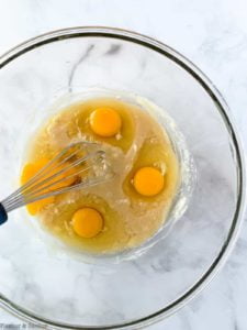 combining melted butter, sweeteners and eggs in a bowl