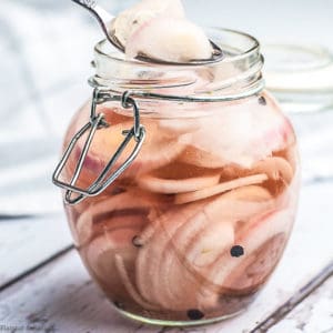 Pickled shallots in a hinged jar with a spoon