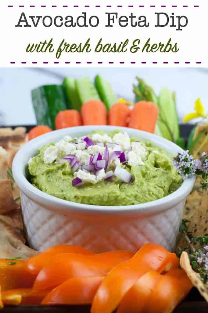 Avocado Feta Dip in a small white bowl surrounded by fresh veggies