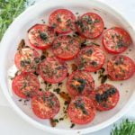 Broiled Italian Tomatoes in a white shallow dish