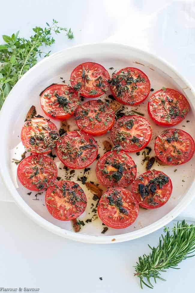 Broiled Italian Tomatoes with Garlic and Herbs in a round white baking dish.