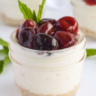 Close up view of one Cherry Almond Cheesecake in a small Mason jar