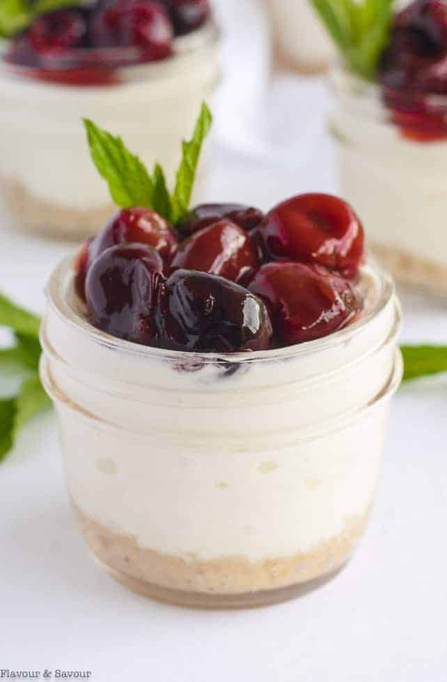 Close up view of one Cherry Almond Cheesecake in a small Mason jar
