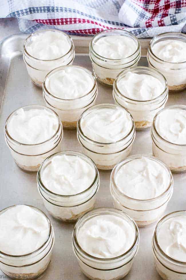 Filling jars with cheesecake mixture for Mini No-Bake Cheesecake.