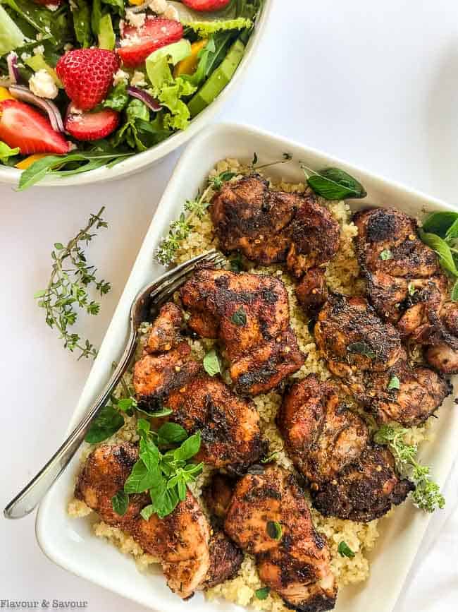 overhead view of a platter of Grilled Cajun Chicken Thighs on quinoa.