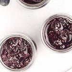3 jars of Blueberry Basil Chia Seed Jam with fresh basil leaves