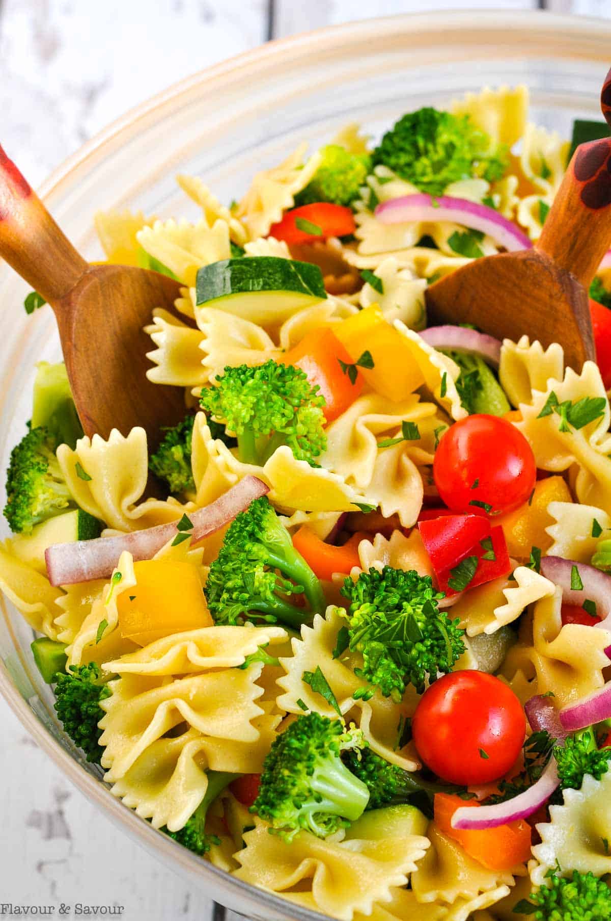 close up view of a bowl of pasta salad with servers