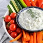 Authentic Tzatziki Dip in a bowl surrounded by fresh vegetables