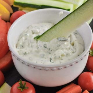 Dipping zucchini stick into Herbed Feta Dip with Lemon