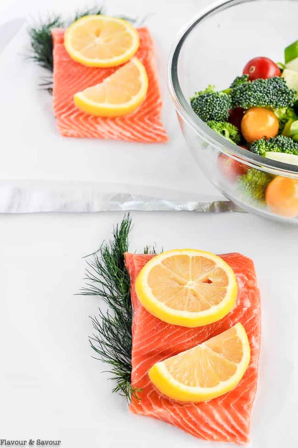 Arranging salmon fillets and vegetables in foil packs.