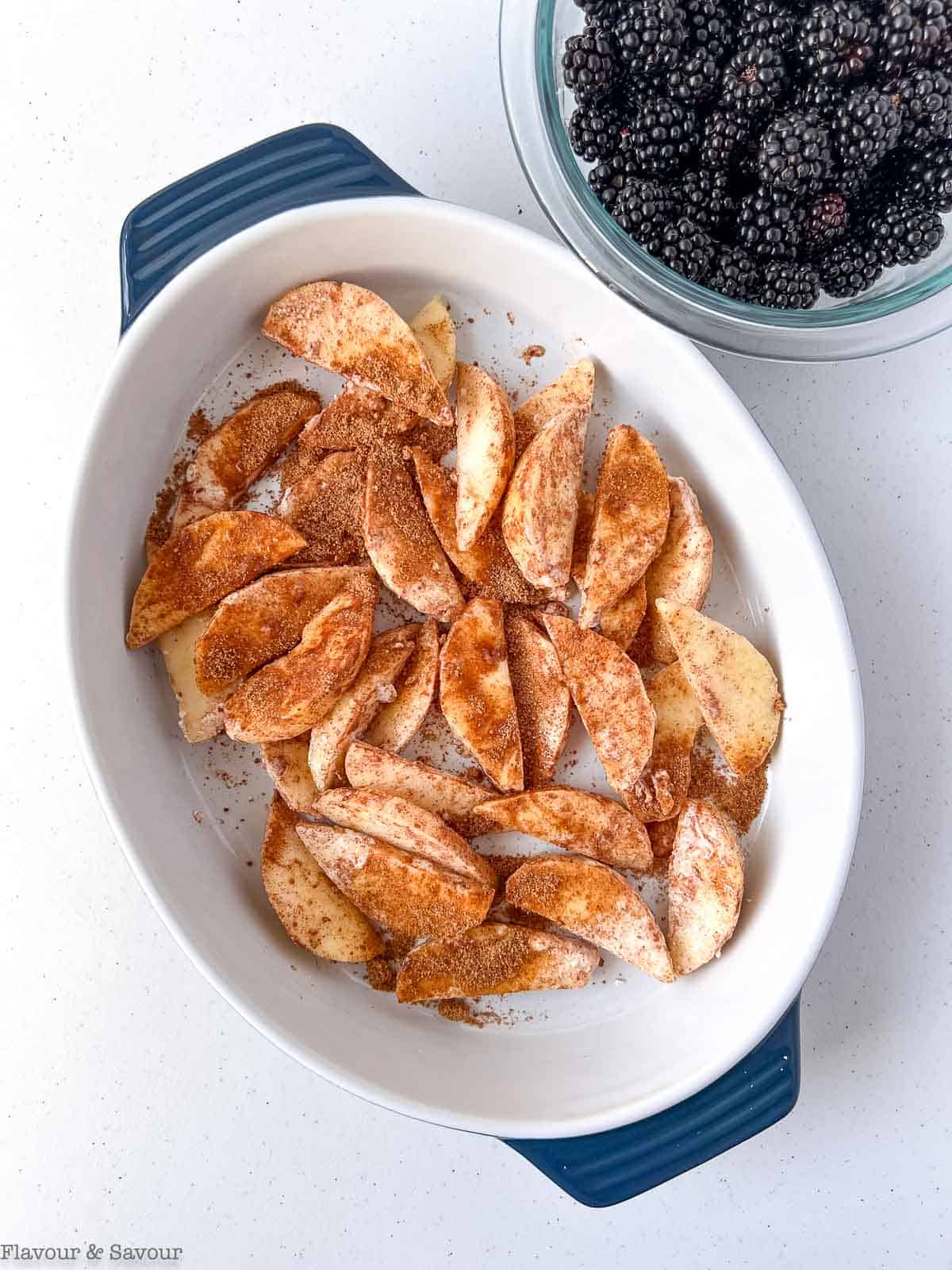 Sliced apples with cinnamon in a baking dish.