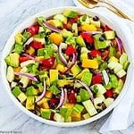 Overhead view of a round bowl with tomato avocado black bean salad.