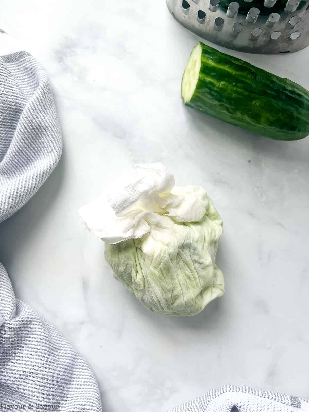 Grated cucumber squeezed out in paper towel for tzatziki.