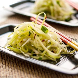 Asian Pear Slaw on a black rectangular plate with chopsticks