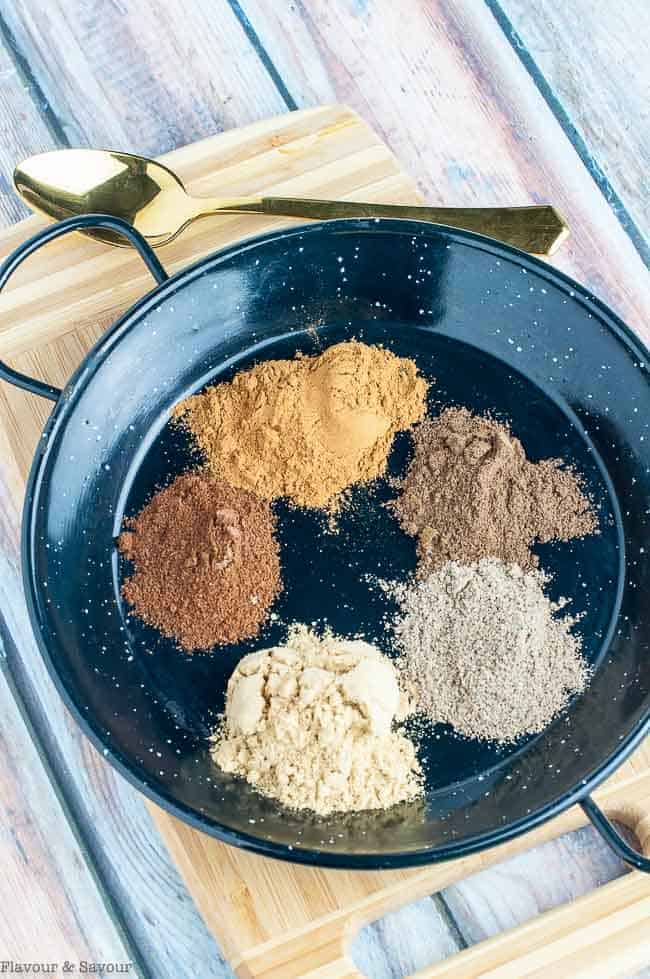 Spices for Chai Spice Mix on a black dish