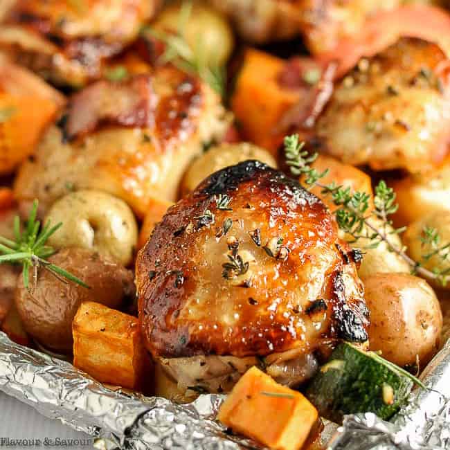 chicken thighs and roasted vegetables on a sheet pan