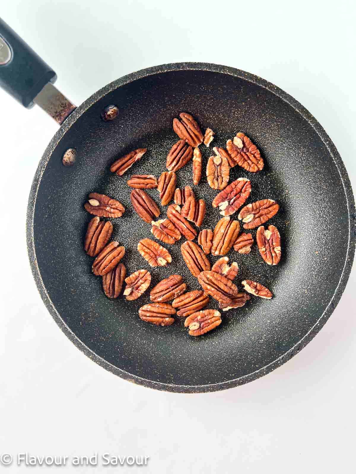 Pecans in a small skillet.