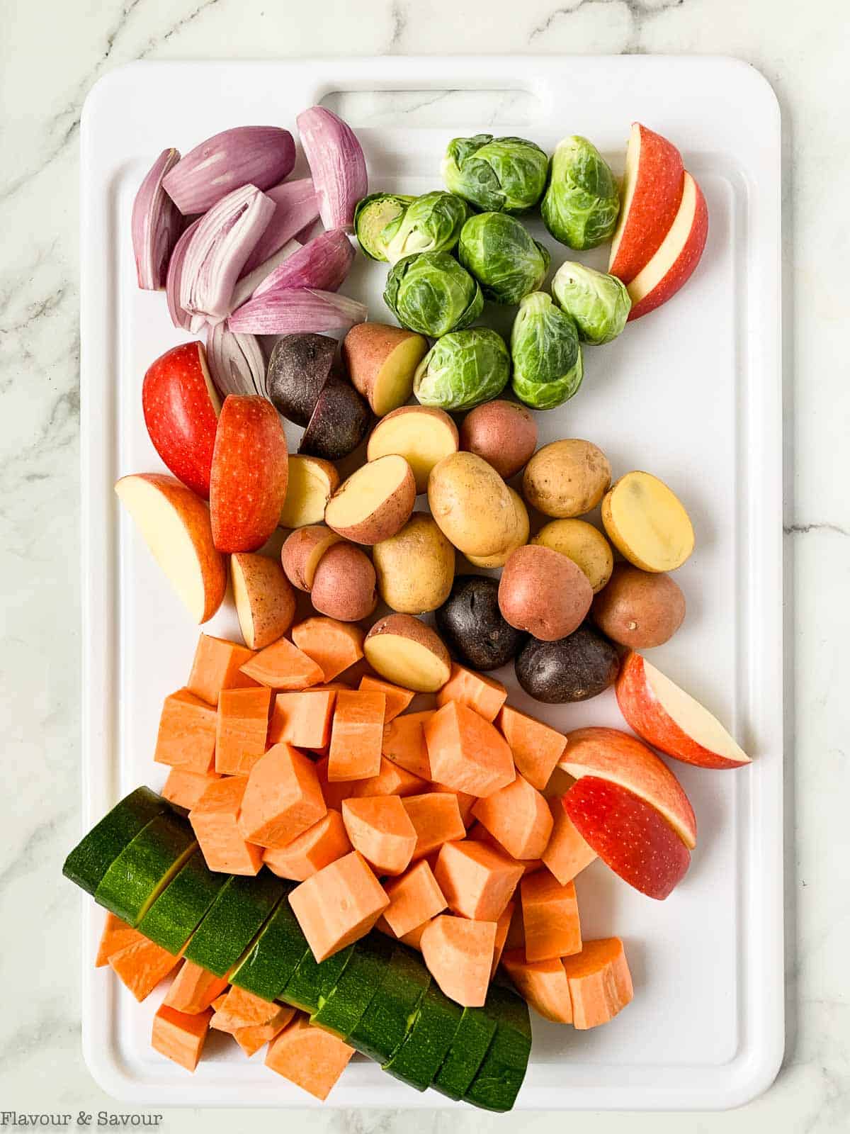Cut vegetables for roasting on a sheet pan.