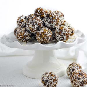 Chocolate Coconut Snowballs on a white pedestal cake plate