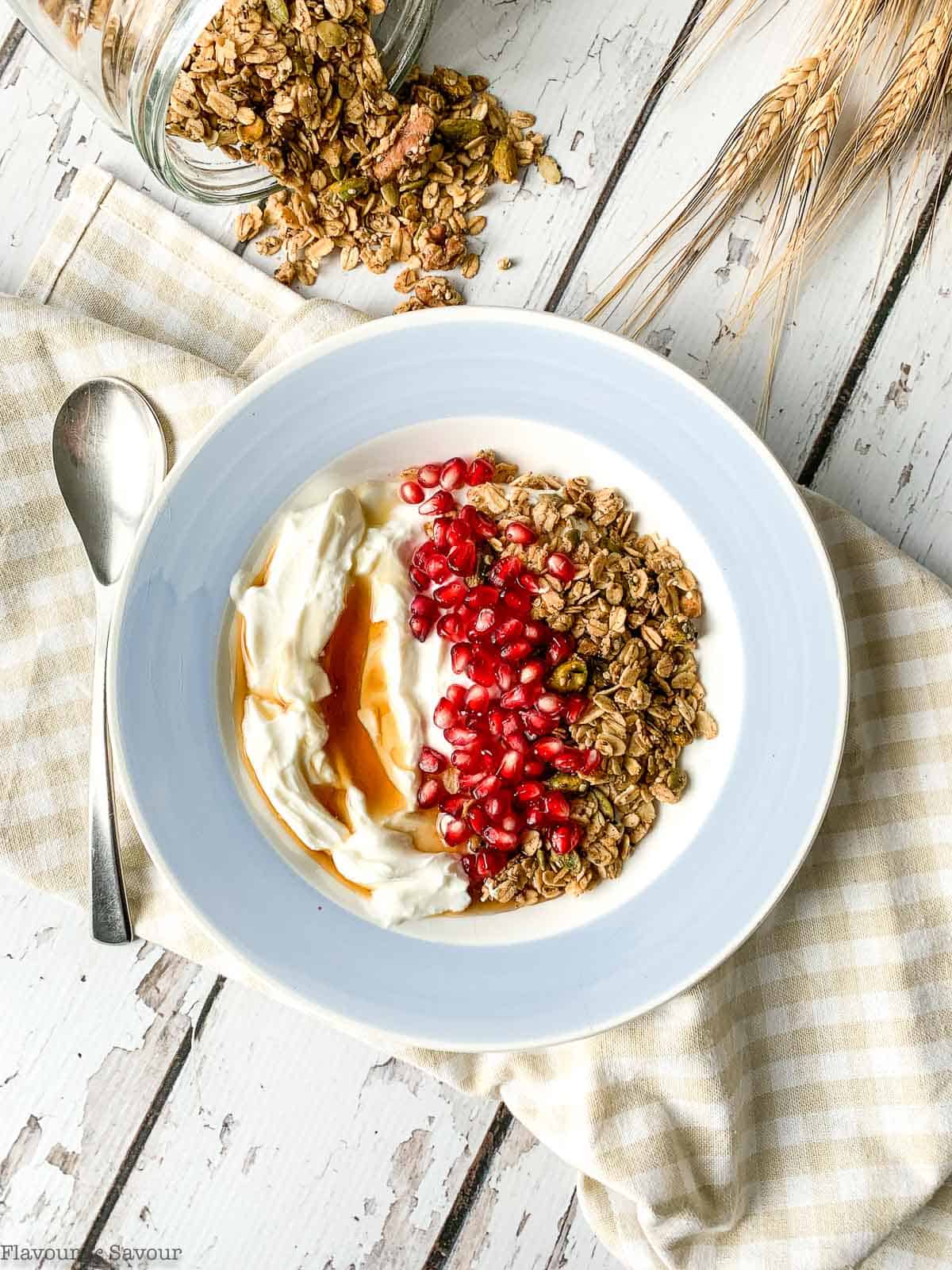 Overhead view of a bowl of pumpkin spice granola with yogurt and pomegranate arils